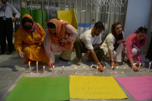 People light candles in the memory of the newborn victims outside the Mother and Child Health ward at the Pakistan Institute of Medical Sciences, in Islamabad, Pakistan, Thursday, Aug. 27, 2026. (AP Photo/M.A. Sheik)