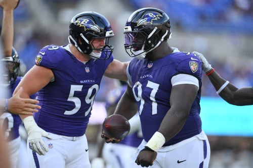 Baltimore Ravens' Basil Okoye (97) celebrates with Aaron Graves (59) after recovering a fumble against the Washington Commanders during the first half of an NFL preseason football game, Friday, Aug. 28, 2026, in Baltimore. (AP Photo/Nick Wass)
