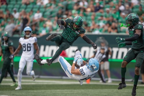 Toronto Argonauts' Tyler Kahmann (82) catches a touchdown pass as Saskatchewan Roughriders' Nelson Lokombo (25) defends during first half CFL action in Regina on Saturday, Aug. 29, 2026. THE CANADIAN PRESS/Kayle Neis