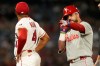 Philadelphia Phillies' Kyle Schwarber, right, gestures after hitting an RBI double as Los Angeles Angels second baseman Christian Moore stands by during the 10th inning of a baseball game Saturday, Aug. 29, 2026, in Anaheim, Calif. (AP Photo/Mark J. Terrill)
