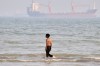 A boy walks on shallow water as commercial vessels are anchored in the Strait of Hormuz off Bandar Abbas, Iran, Monday, Aug. 31, 2026. (Razieh Poudat/ISNA via AP)