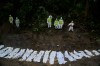 Nepal police personnel prepare the bodies of flash flood victims for a mass burial in Kathmandu, Nepal, Tuesday, Sept. 1, 2026. (AP Photo/Niranjan Shrestha)