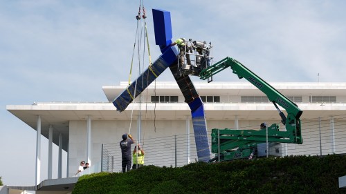 Workers remove the sculpture 