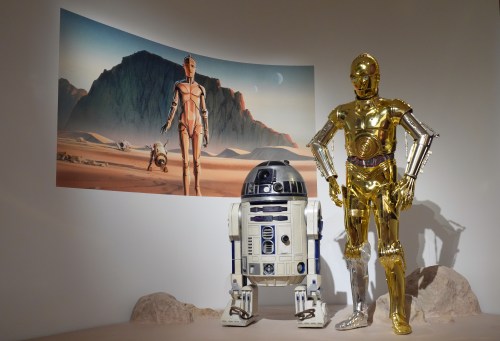 Production designer Norman Reynolds' robot R2-D2, left, and John Mollo's costume for the C-3PO character from the 