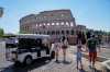 A golf cart sits near the Colosseum as tourists crowd the surrounding streets in Rome, Tuesday, Aug. 18, 2026, highlighting the growing presence of the vehicles in the capital’s historic center as authorities move to curb an industry blamed by critics for worsening congestion, illegal parking, and overtourism. (AP Photo/Gregorio Borgia)