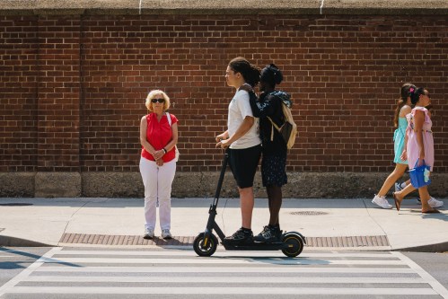 Two kids ride on an electric scooter in Toronto, on Tuesday, Aug. 11, 2026. THE CANADIAN PRESS/Keito Newman