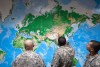 FILE - Soldiers look at a world map as they wait to board a flight in Manas, Kyrgyzstan, on the way home after completing a deployment in Afghanistan, Thursday, Aug. 11, 2011. (AP Photo/David Goldman, file)