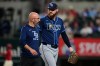 Tampa Bay Rays pitcher Bryan Baker, right, walks off the field with a member of the staff after throwing to the Texas Rangers during the ninth inning of a baseball game Friday, Sept. 4, 2026, in Arlington, Texas. (AP Photo/Tony Gutierrez)
