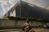 A local resident wears a gas mask as he rides a bicycle past a partially destroyed warehouse after a Russian drone attack in Brovary on the outskirts of Kyiv, Ukraine, Friday, Sept. 4, 2026. (AP Photo/Francisco Seco)