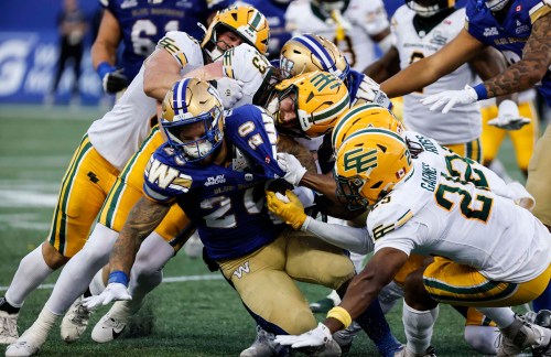 Edmonton Elks defence stops Winnipeg Blue Bombers' Brady Oliveira (20) during second half CFL football action in Winnipeg on Thursday, June 25, 2026. THE CANADIAN PRESS/John Woods