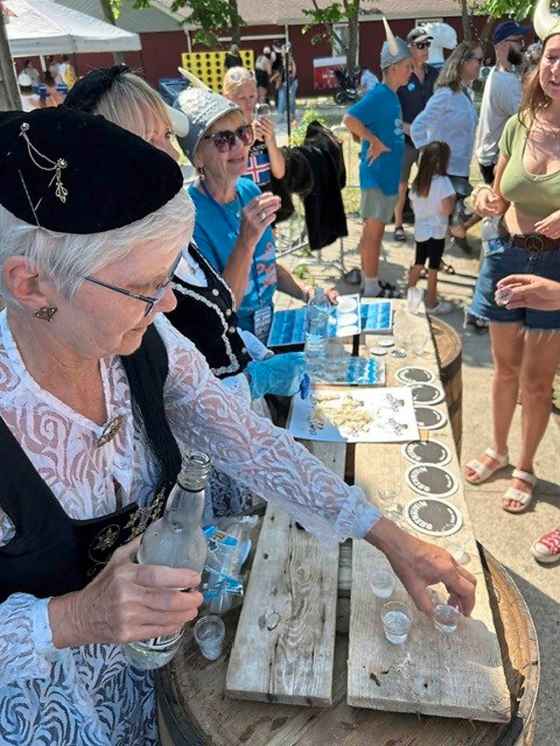Volunteers prepare the hardfiskur and Brennivin shots for those about to get Dinged. (Ben Sigurdson / Free Press)