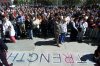 A crowd gathers for three minutes of silence in front of a chalk sign reading 