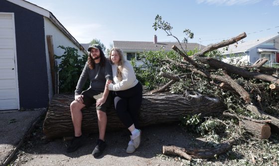 Tanner Lemieux and his wife Cassidy Lemieux in their backyard, surrounded by damage from Sunday’s storm. (Ruth Bonneville / Free Press)