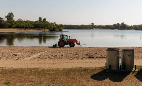 Photos by MIKE DEAL / FREE PRESS
                                A tractor smooths out the beach in St. Malo Provincial Park and scapes away goose feces in an attempt to reduce E. coli levels in the water.