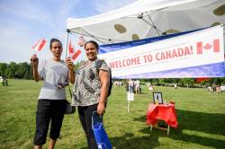 Mike Sudoma/Free Press
                                Gewra Mengisteab (left) and her friend Genet Haile wave their Canadian flags after finishing the Refugee Highway.