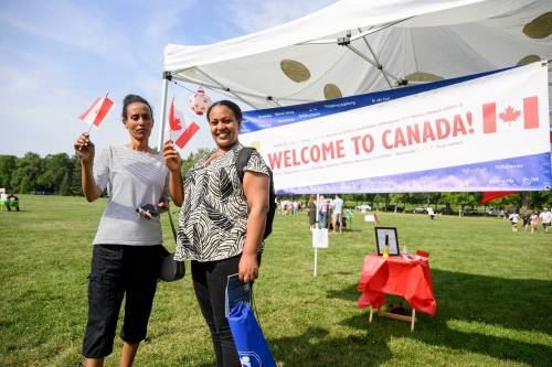 Mike Sudoma/Free Press
                                Gewra Mengisteab (left) and her friend Genet Haile wave their Canadian flags after finishing the Refugee Highway.