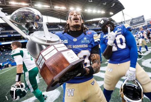 JOHN WOODS / THE CANADIAN PRESS 

Winnipeg Blue Bombers’ Trey Vaval (23) and Nuer Gatkuoth (40) celebrate a win over the Saskatchewan Roughriders with the Banjo Bowl trophy following CFL action in Winnipeg on Saturday.