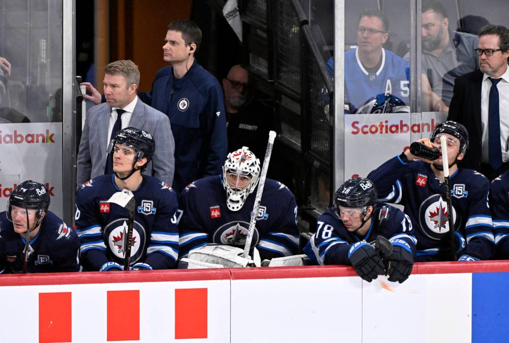 Fred Greenslade / THE CANADIAN PRESS FILES
Winnipeg Jets goaltender Connor Hellebuyck (centre) turning up to training camp will be a major plot twist since the netminder has been absent so far this fall.