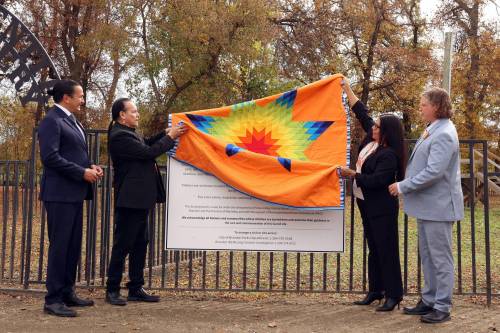 Tim Smith/The Brandon Sun
                                Manitoba Premier Wab Kinew, Manitoba Keewatinowi Okimakanak Grand Chief Garrison Settee, Sioux Valley Dakota Nation Chief Jennifer Bone and Brandon Mayor Jeff Fawcett remove a star blanket to unveil a sign at the Brandon Residential School Cemetery at the former Turtle Crossing Campground, Tuesday.