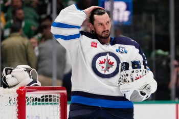 FILE - Winnipeg Jets goaltender Connor Hellebuyck stands by the net during a time out from play against the Dallas Stars in the first period of an NHL hockey game, April 2, 2026, in Dallas. (AP Photo/Tony Gutierrez, File)