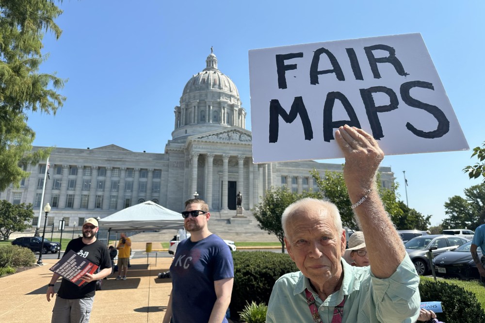 This smartphone photo shows Steve Perry of Kansas City holding a sign opposing Congress' plan to redistrict Missouri Wednesday, Sept. 2, 2026, outside the State Capitol in Jefferson City, Mo. (AP Photo/David A. Lieb).