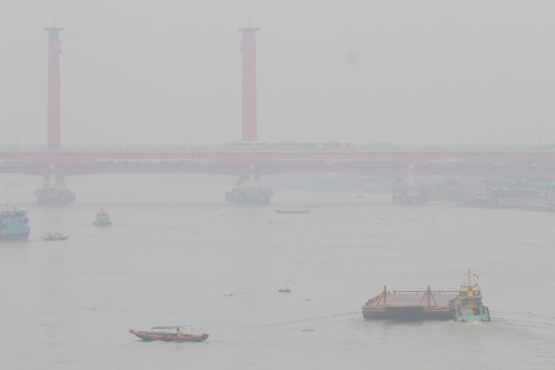 Boats cruise on Musi River amid haze from wildfires in Palembang, South Sumatra, Indonesia, Wednesday, Sept. 9, 2026. (AP Photo/Muhammad Hatta)