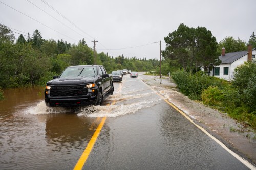 Vehicles drive along Old Route 4 in floodwater conditions, in Richmond County, Cape Breton, N.S., Saturday, Sept. 5, 2026. THE CANADIAN PRESS/Steve Wadden