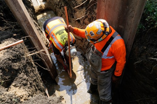 Workers install a copper pipe to replace a lead service line that brings drinking water to homes Tuesday, July 21, 2026, in Chicago. (AP Photo/Alyssa Goodman)