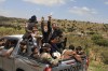 Yemeni civilians celebrate while riding in the back of a pickup truck in the Bani Matar district, Yemen, Saturday, Sept. 12, 2026, as they follow a convoy carrying Houthi prisoners freed in Mokha on its way to Sanaa following the Houthi takeover of the southern Red Sea port city. (AP Photo/STR)