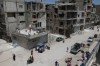 Daily life continues among damaged buildings, some under reconstruction, in the Yarmouk Palestinian refugee camp, devastated by years of fighting and displacement during the Syrian war, in Damascus, Syria, Tuesday, May 19, 2026. (AP Photo/Ghaith Alsayed)