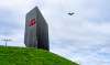 A plane flies past a sign for Montreal-Trudeau International Airport in Montreal on Tuesday, Aug. 25, 2026. THE CANADIAN PRESS/Christinne Muschi