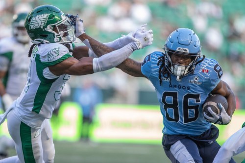 Toronto Argonauts' Damonte Coxie (86) stiff arms Saskatchewan Roughriders' Jonathan Edouard (31) during first half CFL football action in Regina, on Friday, June 26, 2026. THE CANADIAN PRESS/Kayle Neis