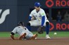 Detroit Tigers' Kevin McGonigle, left, dives back into second base ahead of the tag from Toronto Blue Jays second baseman Ernie Clement (22) on a pick-off tag attempt during first inning MLB baseball action in Toronto on Tuesday, Sept. 15, 2026. THE CANADIAN PRESS/Jon Blacker