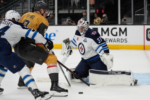 Vegas Golden Knights center Jack Eichel (9) attempts a shot on Winnipeg Jets goaltender Connor Hellebuyck (37) during the second period of an NHL hockey game Monday, April 13, 2026, in Las Vegas. (AP Photo/John Locher)