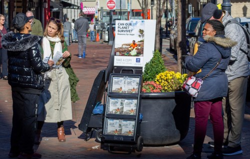FILE - A woman shares Jehovah's Witnesses' literature with a passerby in downtown Pittsburgh on Nov. 13, 2023. (AP Photo/Peter Smith, File)
