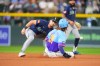 Seattle Mariners second baseman Cole Young, left, misses a pickoff throw as Colorado Rockies' Jake McCarthy, right, steals second in the fourth inning of a baseball game Friday, Sept. 18, 2026, in Denver. (AP Photo/David Zalubowski)