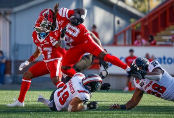 Ottawa Redblacks' Kori Roberson Jr., right, and Lucas Cormier, centre, bring down Calgary Stampeders' Deonta McMahon during first half CFL football action in Calgary, Saturday, Sept. 19, 2026. THE CANADIAN PRESS/Jeff McIntosh