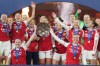 FILE - Arsenal's team captains Kin Little, left, and Leah Williamson, right, lift the trophy after winning the Women's Champions Cup final soccer match between Arsenal FC and SC Corinthians in London, Sunday, Feb. 1, 2026. (AP Photo/Alastair Grant, File)