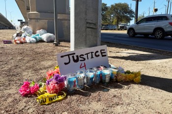 Flowers and candles are placed, Monday, Sept. 21, 2026, near the site where an ICE officer shot a Venezuelan man during a traffic stop the day before, in Austin, Texas. (AP Photo/Jesse Bedayn)