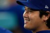 Los Angeles Dodgers' Shohei Ohtani smiles as he sits in the dugout during the eighth inning of a baseball game against the San Diego Padres, Tuesday, Sept. 22, 2026, in Los Angeles. (AP Photo/Mark J. Terrill)