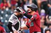 Arizona Diamondbacks' Nolan Arenado, front, gestures as he crosses home plate after hitting a two-run home run as Colorado Rockies catcher Brett Sullivan waits for play to resume in the first inning of a baseball game Thursday, Sept. 24, 2026, in Denver. (AP Photo/David Zalubowski)