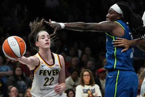 Indiana Fever guard Caitlin Clark (22) passes the ballaround Minnesota Lynx forward Natasha Howard, right, during the first half of a WNBA basketball game, Thursday, Sept. 24, 2026, in Minneapolis. (AP Photo/Ellen Schmidt)