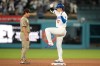 Los Angeles Dodgers' Shohei Ohtani, right, gestures after hitting a double as San Diego Padres second baseman Sung-Mun Song looks on during the ninth inning of a baseball game Thursday, Sept. 24, 2026, in Los Angeles. (AP Photo/Mark J. Terrill)