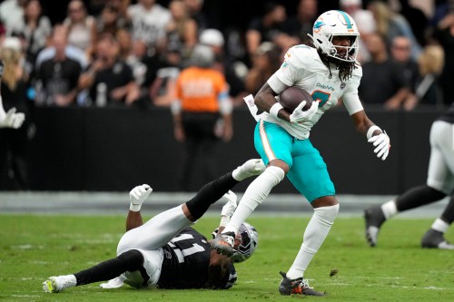 Miami Dolphins wide receiver Caleb Douglas (7) breaks a tackle by Las Vegas Raiders safety Jeremy Chinn (11) after catching a pass during the first half of an NFL football game, Sunday, Sept. 13, 2026, in Las Vegas. (AP Photo/Ross D. Franklin)