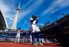 Blue Jays designated hitter George Springer (4) walks on the field before the start of a Major League Baseball game against the Cincinnati Reds in Toronto on Sept. 27, 2026. THE CANADIAN PRESS/Frank Gunn