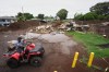 A man rides with his son near where a home was destroyed during last month's Hurricane Lala, as floodwaters from Hurricane Nolo recedes Sunday, Sept. 27, 2026, in Naalehu, Hawaii. (AP Photo/Gregory Bull)