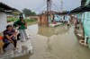 Residents of a low-lying neighborhood watch as floodwaters submerge their area following heavy rains in Kanpur, India, on Sept. 22, 2026. (AP Photo)