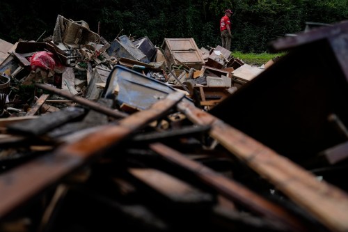 FILE - A man stands near a pile of debris as residents clean up in Fleming-Neon, Ky., Aug. 5, 2022, after massive flooding the previous week. (AP Photo/Brynn Anderson, File)