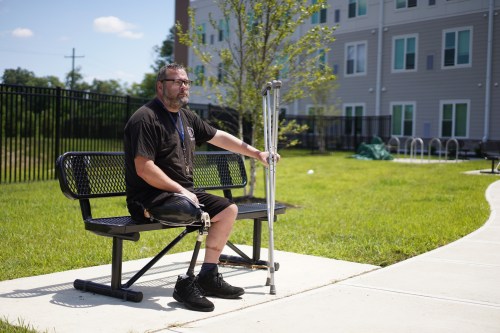 Phillip Sieveking sits outside his permanent supportive apartment in Louisville, Ky., on Thursday, July 30, 2026. (AP Photo/Mary Conlon)