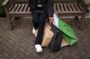 A person sits on a bench with shopping bags on Boxing Day in Richmond, B.C., on Friday, December 26, 2025. THE CANADIAN PRESS/Ethan Cairns